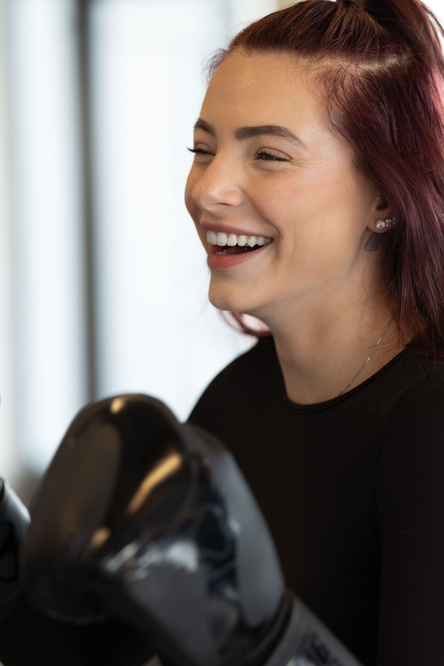 Lachende vrouw met een bokshandschoen tijdens bokstraining bij Building You in Etten-Leur