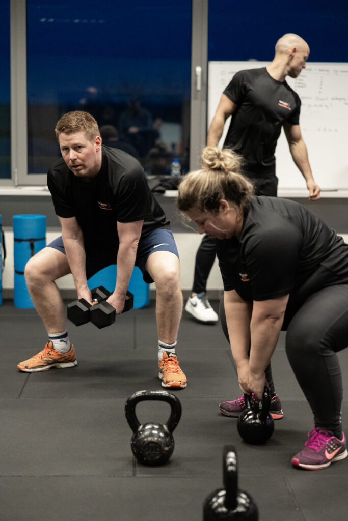 Coach en deelnemer tillen kettlebells tijdens small group training bij Building You in Etten-Leur