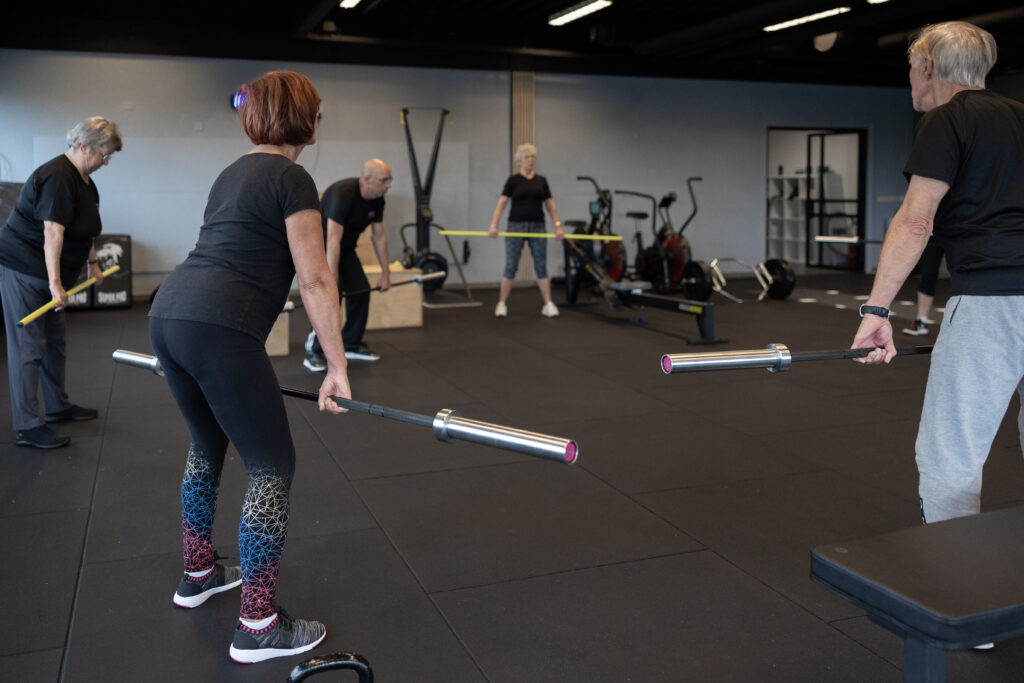 Senioren trainen kracht met stangen en bandjes onder begeleiding bij Building You in Etten-Leur